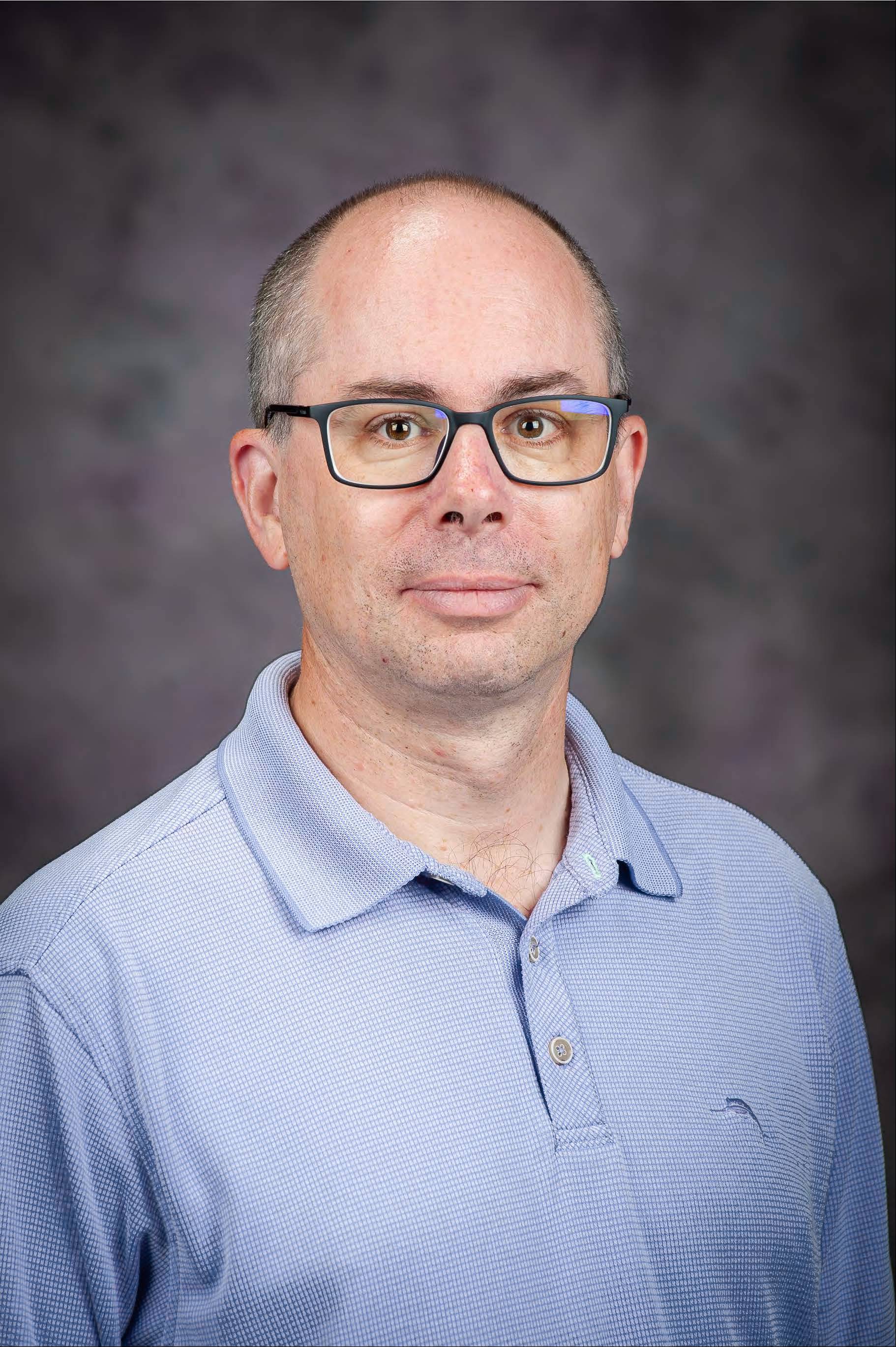 Director, Jason Maseberg-Tomlinson, Ph.D., in purple shirt and tie.