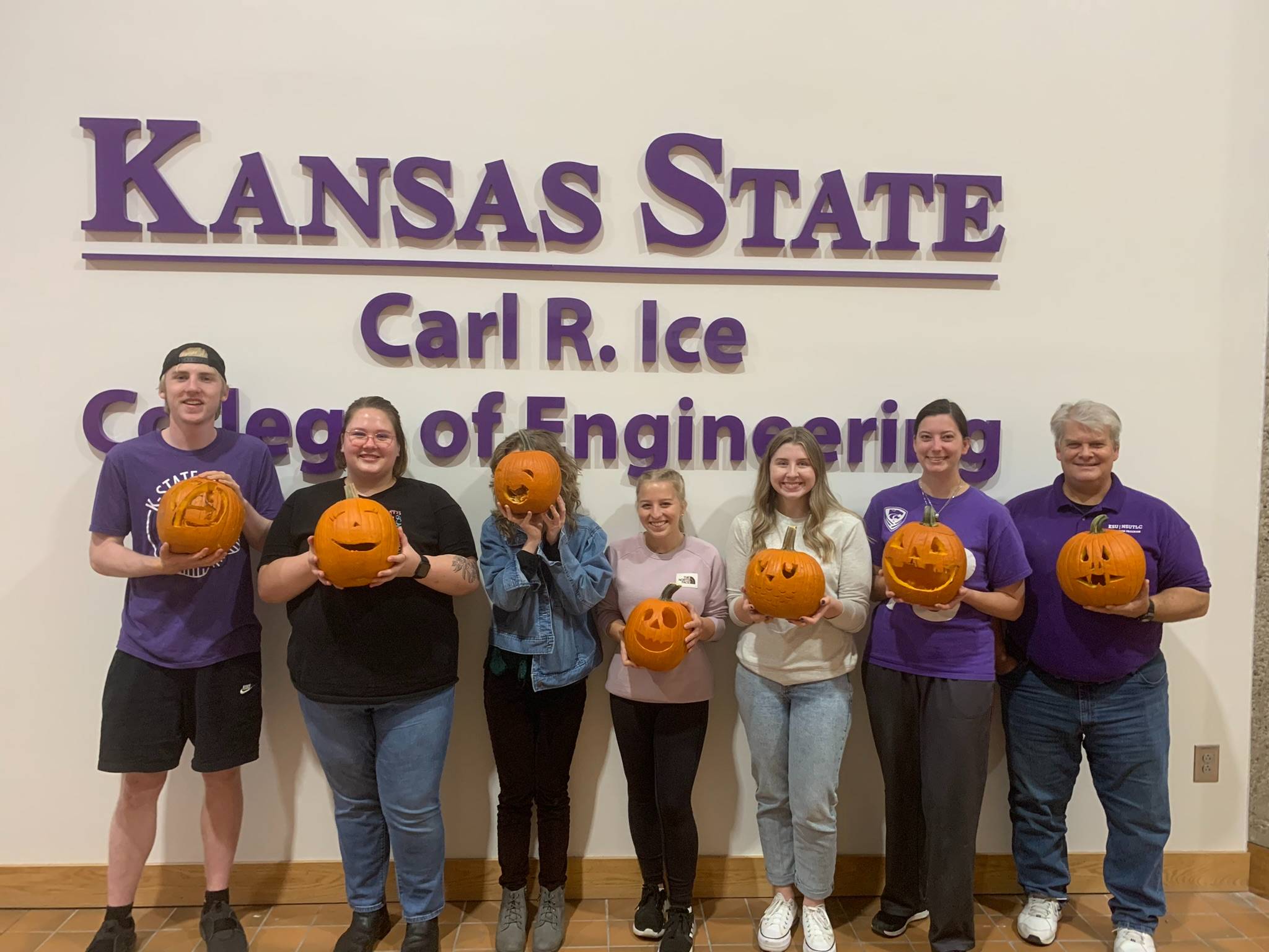 EMBS members pose with their carved pumpkins.