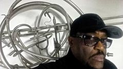 Artist Garry R. Bibbs with his piece Stainless Steel Wall Piece