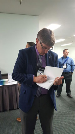 Grant Chapman signs copies of the recently released NAFSA publication