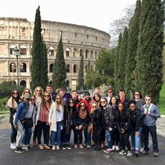 The study abroad group poses outside the Colosseum