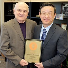 Dr. Franke Blecha presents the Zoetis Research Excellence Award to Dr. Weiping Zhang