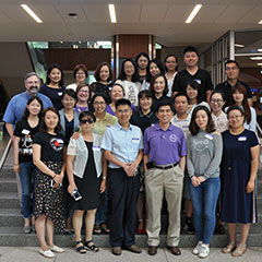 The group poses in the College of Business atrium.