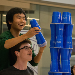 Competing for first place, two students participate in a cup stacking challenge during Hack K-State 2017.