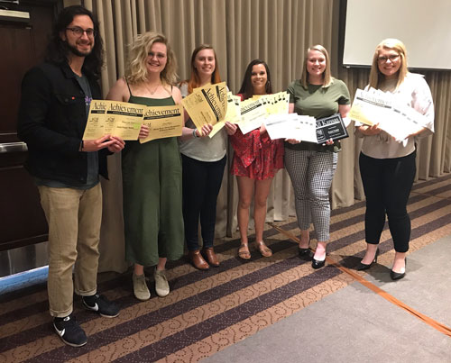 Peter Loganbill, Olivia Bergmeier, Dene Dryden, Paige Eichkorn, Kaylie McLaughlin and Molly Hackett display some of the more than 30 awards won by student publications for their work covering K-State in 2018.  