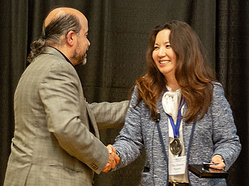 James Sacco, Central States Society of Toxicology president, presents the John Doull Award to K-State Annelise Nguyen.  