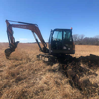 K-State professor DeAnn Presley used an excavator to dig a 12 foot wide trench in her backyard K-State professor DeAnn Presley used an excavator to dig a 12 foot wide trench in her backyard