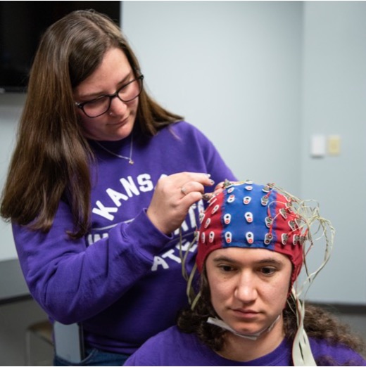Researcher setting up the electroencephalogram (EEG) system to measure brain activity.