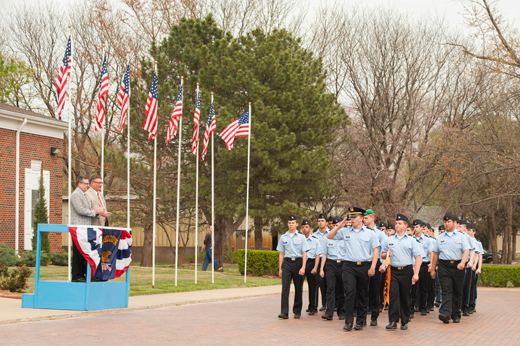 Cadets march by Kansas State University President Kirk Schulz, left, and St. John's Military School President Andrew England 