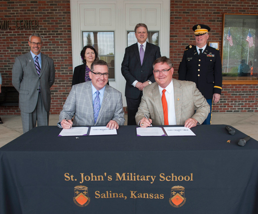 Kansas State University President Kirk Schulz, left, and St. John's Military School President Andrew England sign an institutional partnership agreement that will serve the collegiate needs of St. John's students.