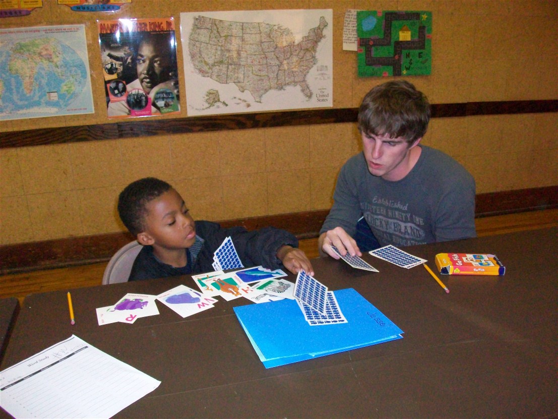 Tyler Link practices flashcards with a student at the Douglass Center.