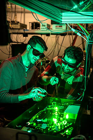 Pavan Muddukrishna, left, and Sajed Hosseini-Zavareh check the alignment of a laser in the James R. Macdonald Laboratory.