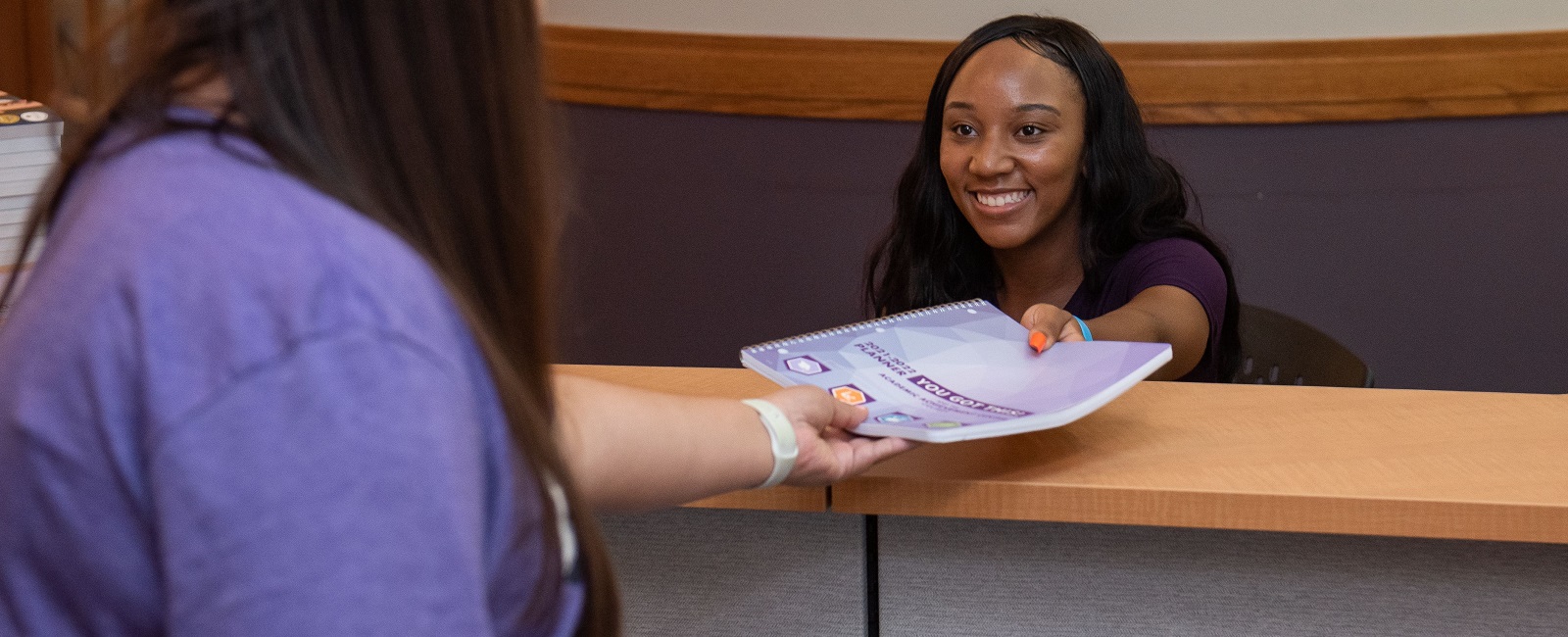 Student being handed a planner