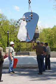 Installation of memorial sculpture, American flag reflected