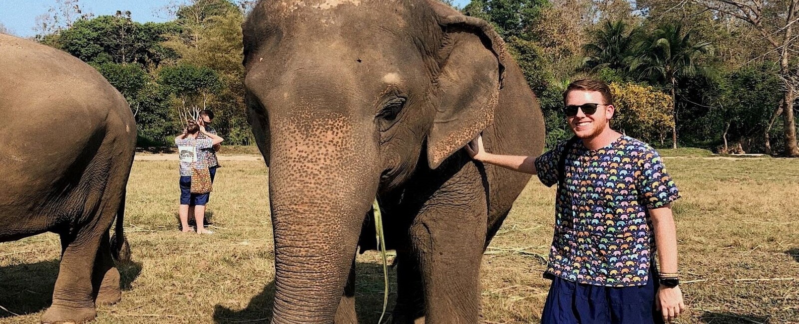 K-State student studying abroad in Thailand and standing with an elephant