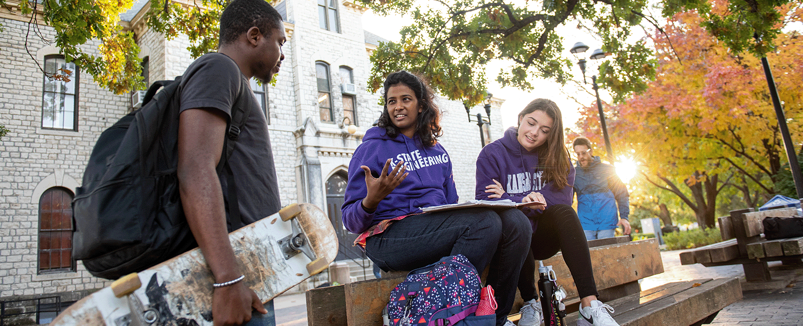 Students smile for the camera outside Anderson Hall on the K-State campus