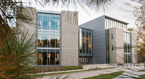 K-State's College of Business Administration building is seen through the trees.