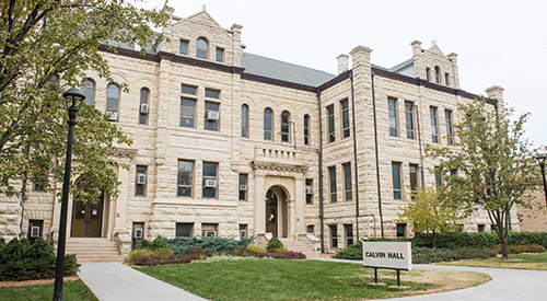 Calvin Hall stands under a cloudy sky. 