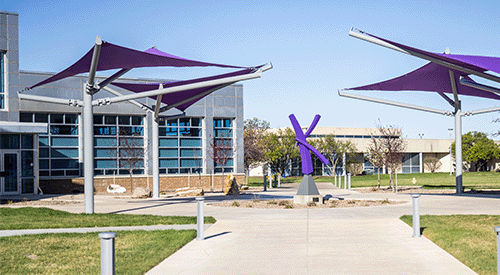 An outdoor courtyard on K-State Salina's campus is punctuated with purple shades.