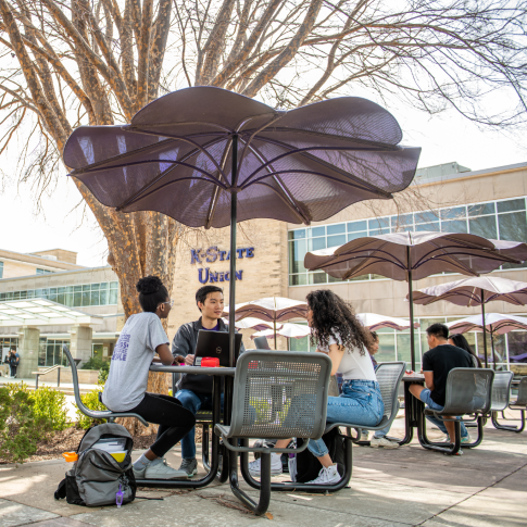 Students sitting at tables in Bosco Plaza