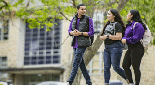 A group of students walks on the K-State campus