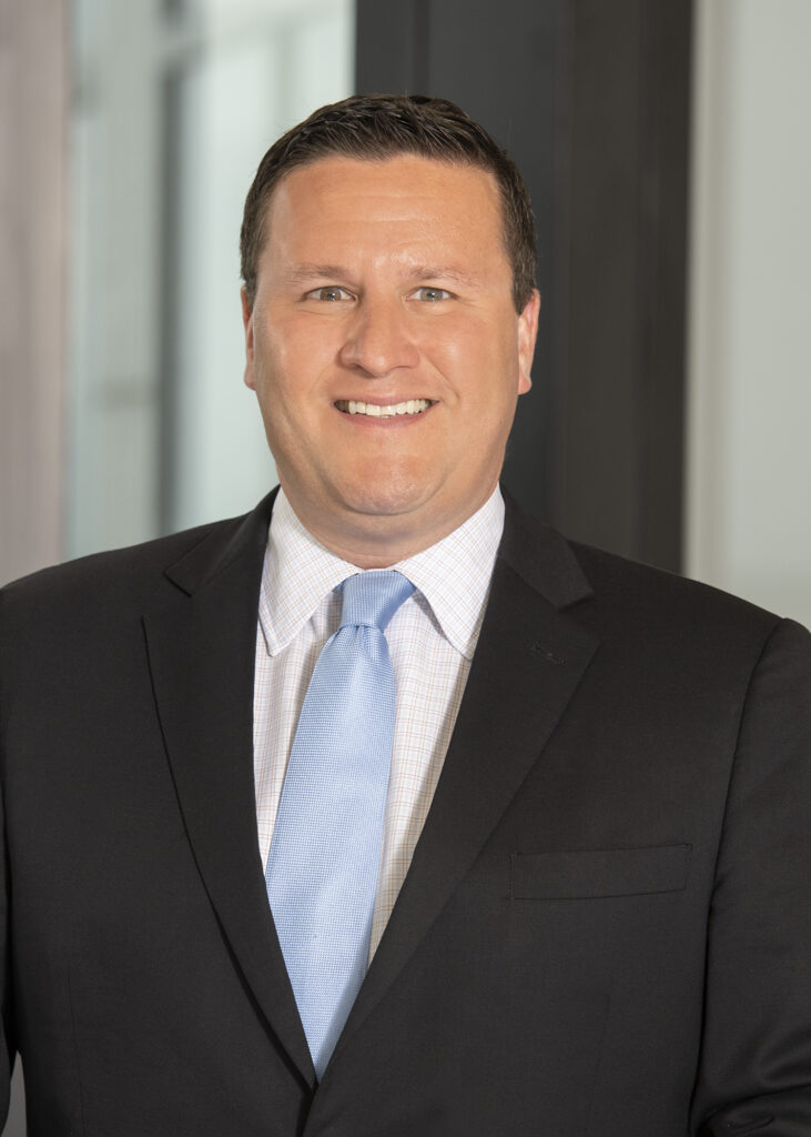 Professional headshot of David Waters in a black suit and blue tie