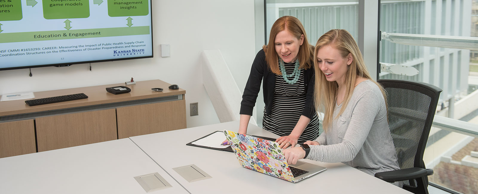 Professor working with student on laptop