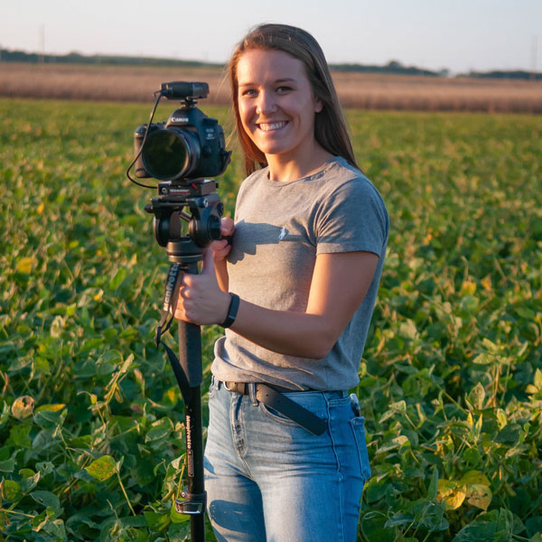 Agriculture student with camera in field.