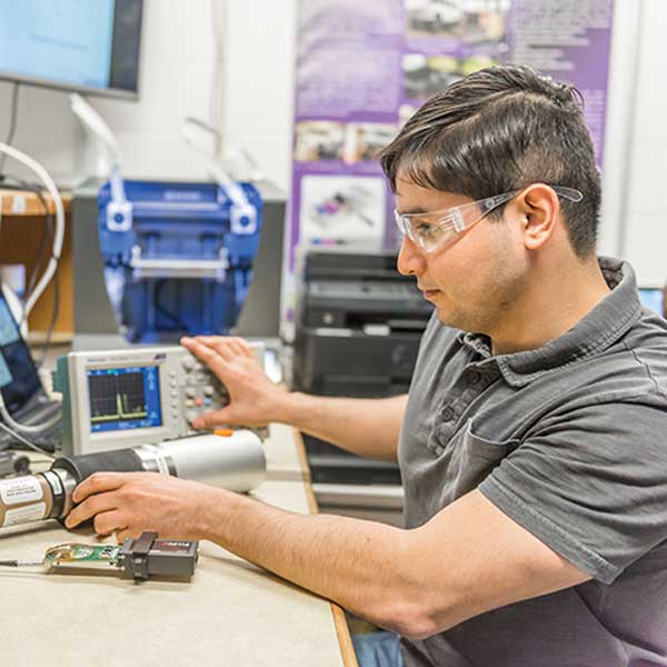 An engineering student works in a studio classroom setting.