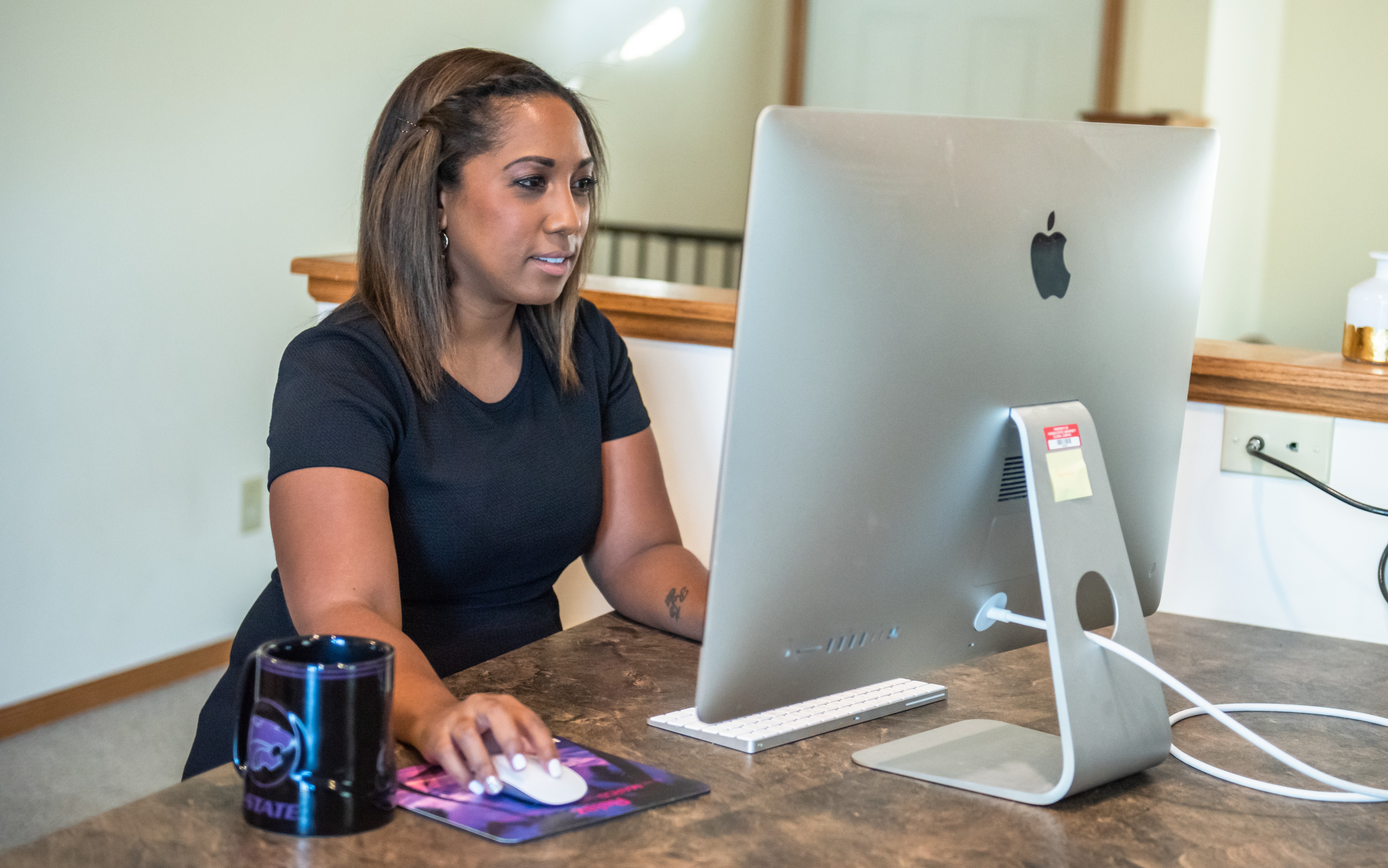 Online student sitting at her desk with a cup of coffee.