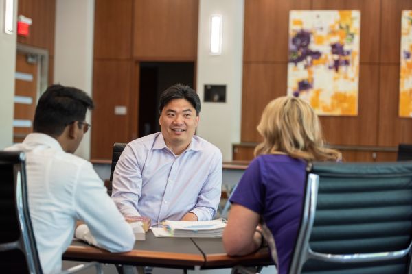 Leaders sitting at a table having a meeting with two other employees