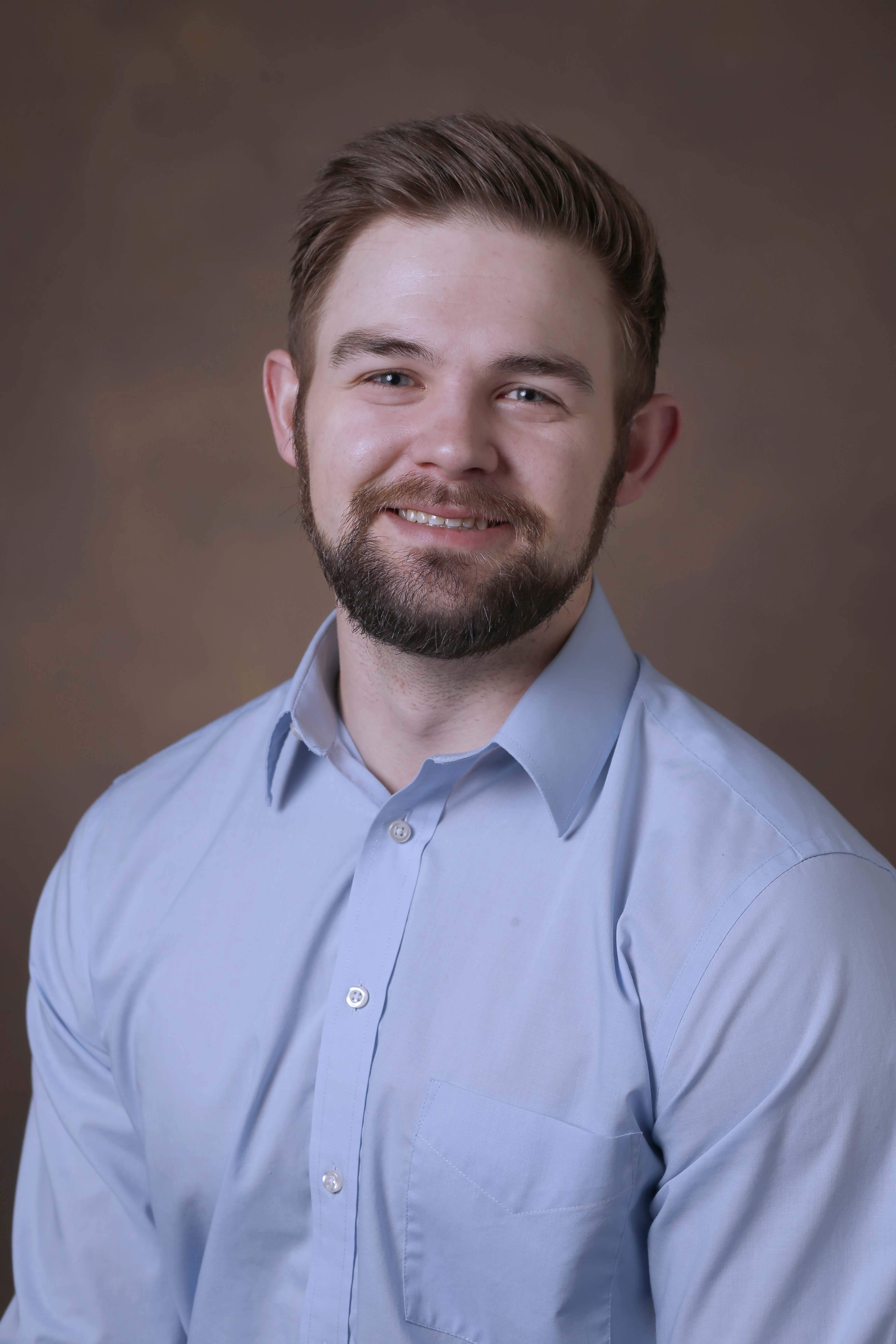 Image of Kyle Braun smiling in a blue button up shirt.