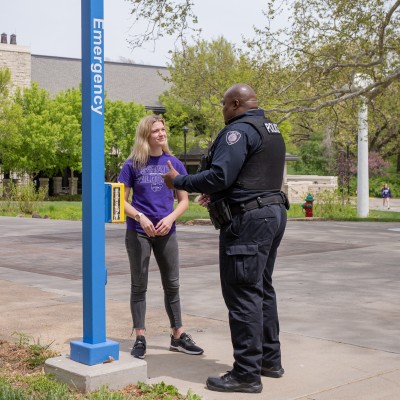 student and k-state police officer talking at one of the emergency blue phones