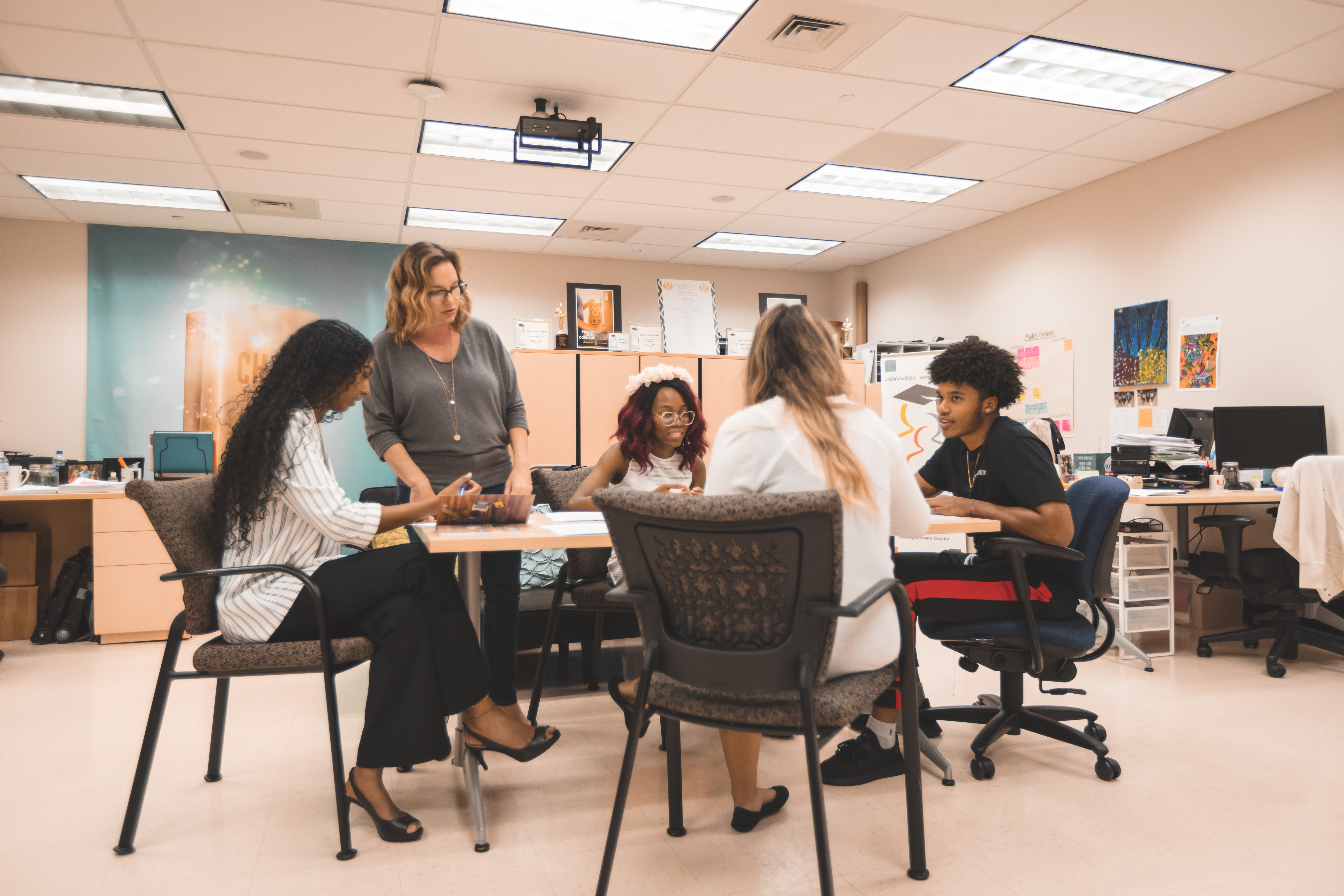 Image of Amanda Frey, graduate, working with four students whom are a part of her community mentoring program in Florida.