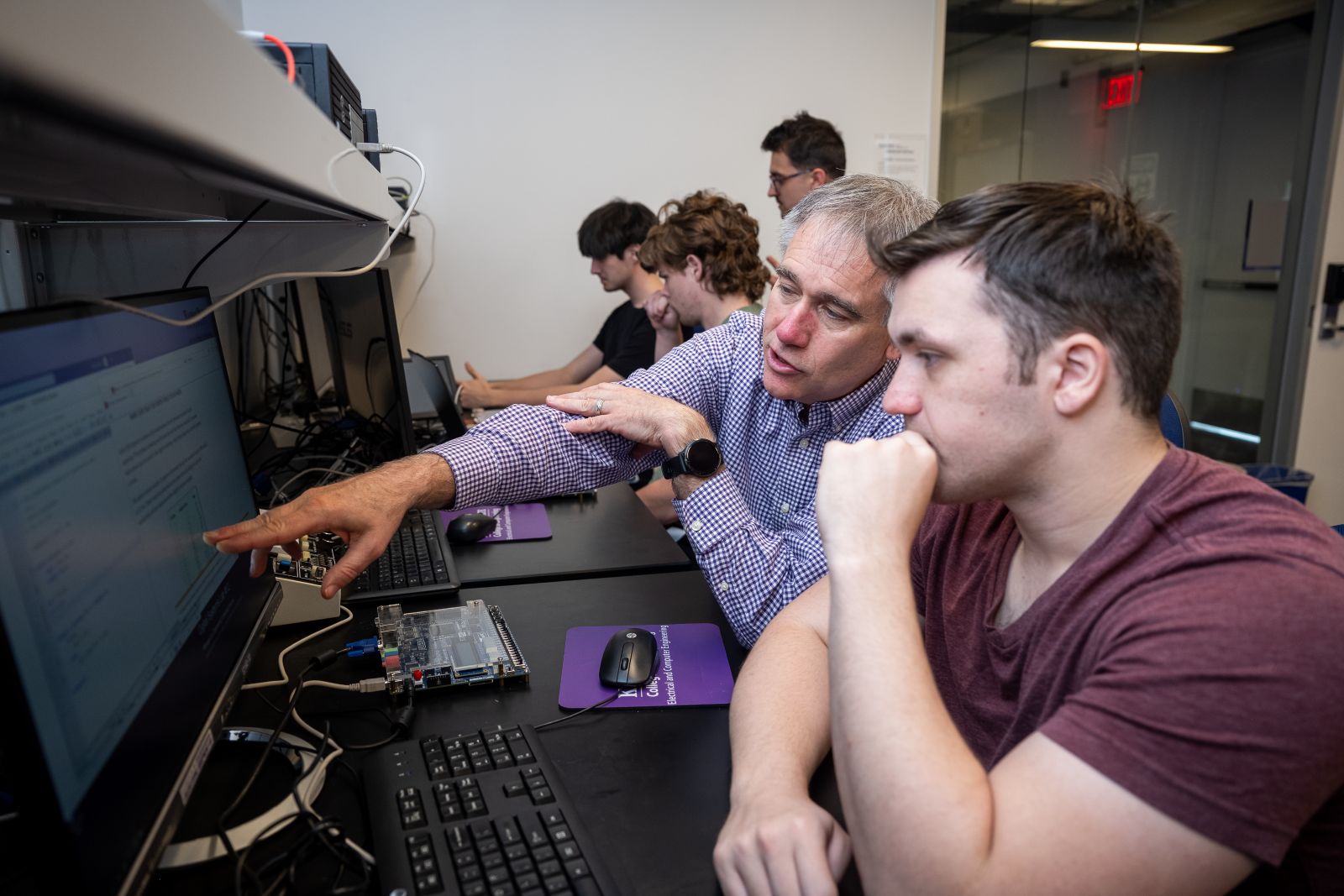 Image of teacher working with computer science student on their computer.