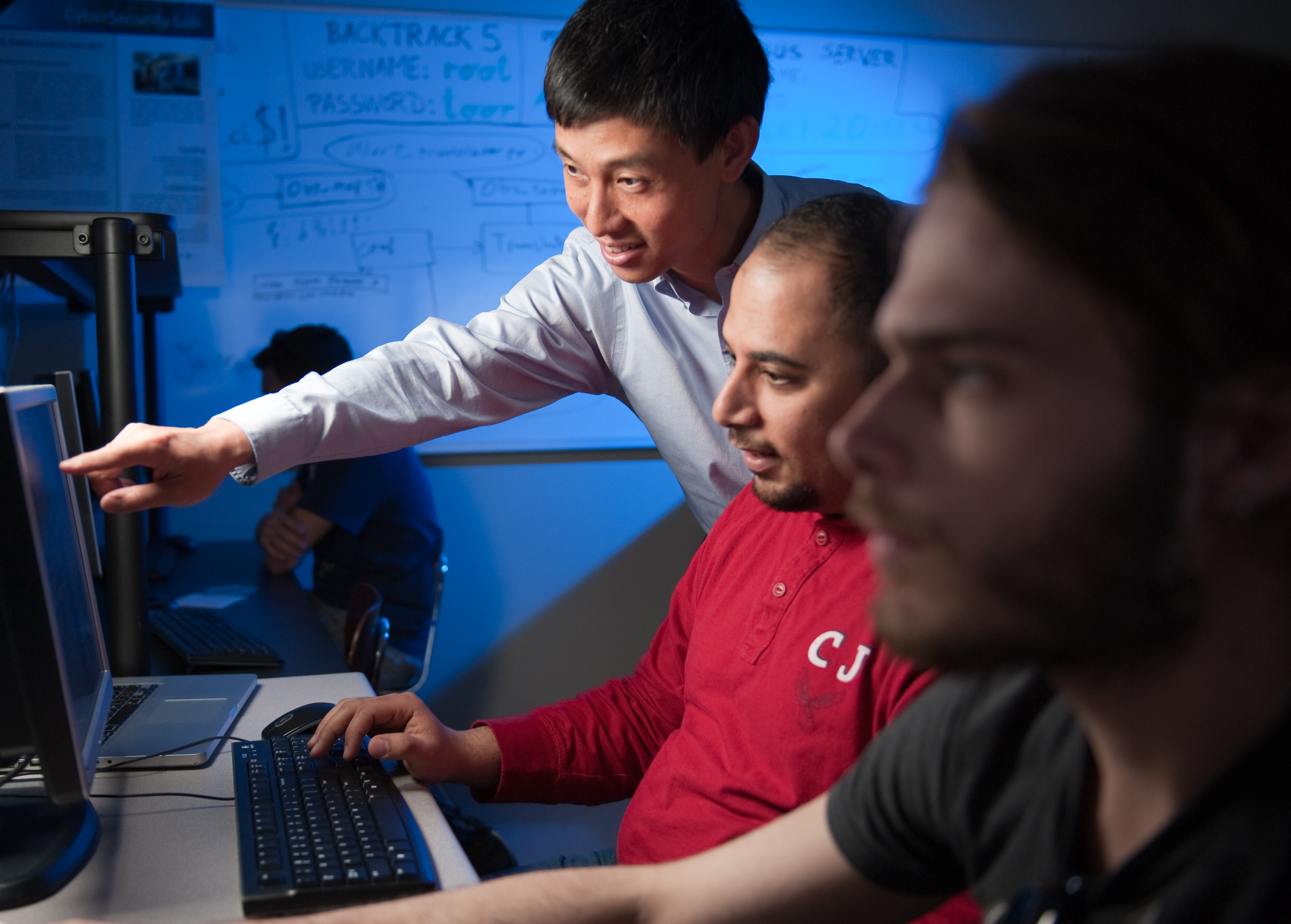 students look at code on a computer