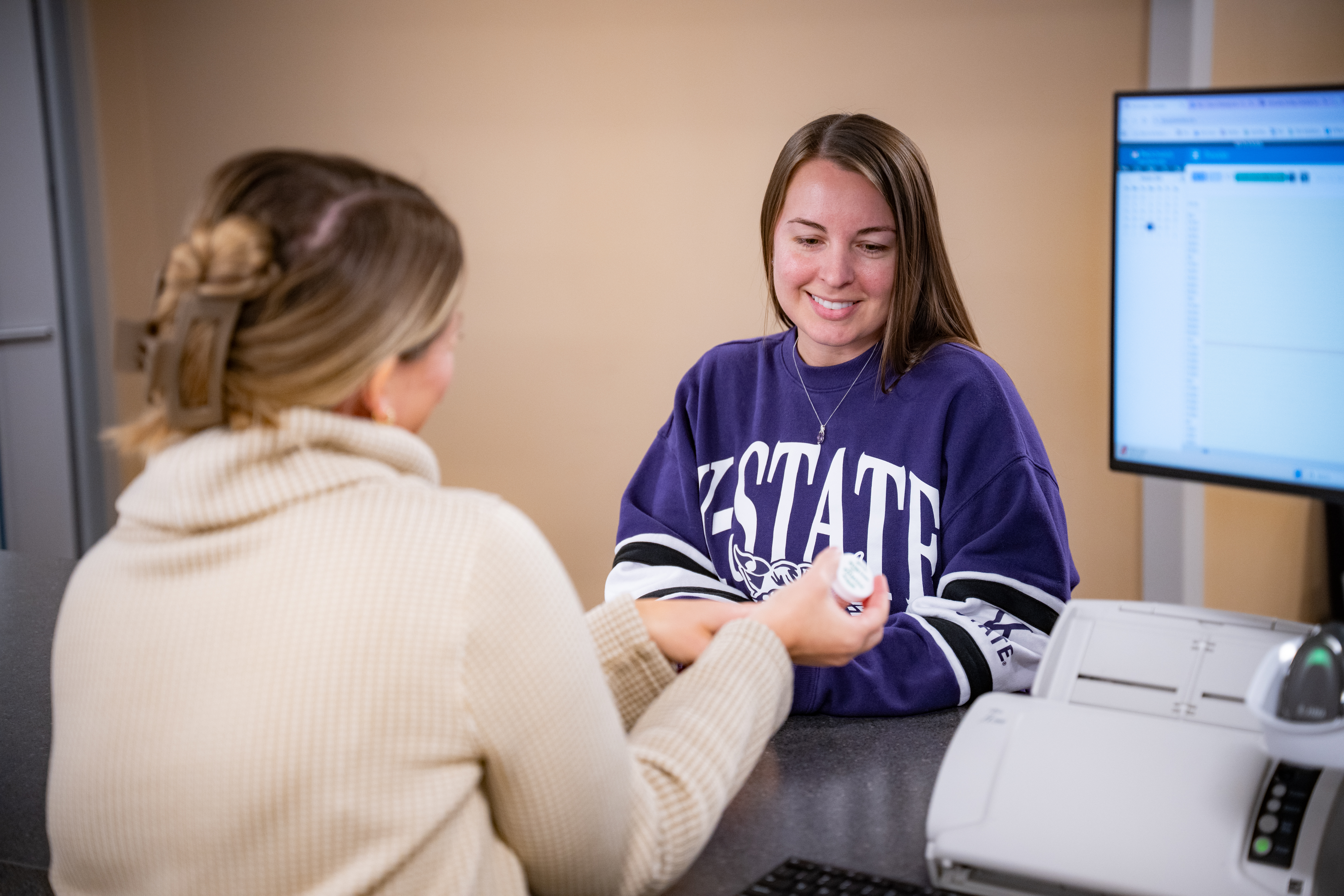 Student talking with a staff member talking about medicine