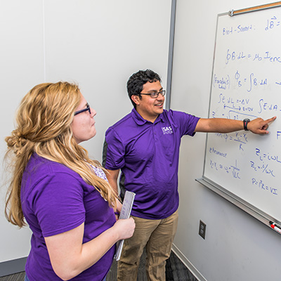 Two people at a white board