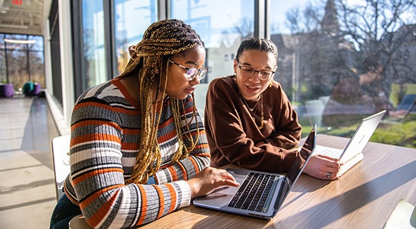 Two people looking at a laptop