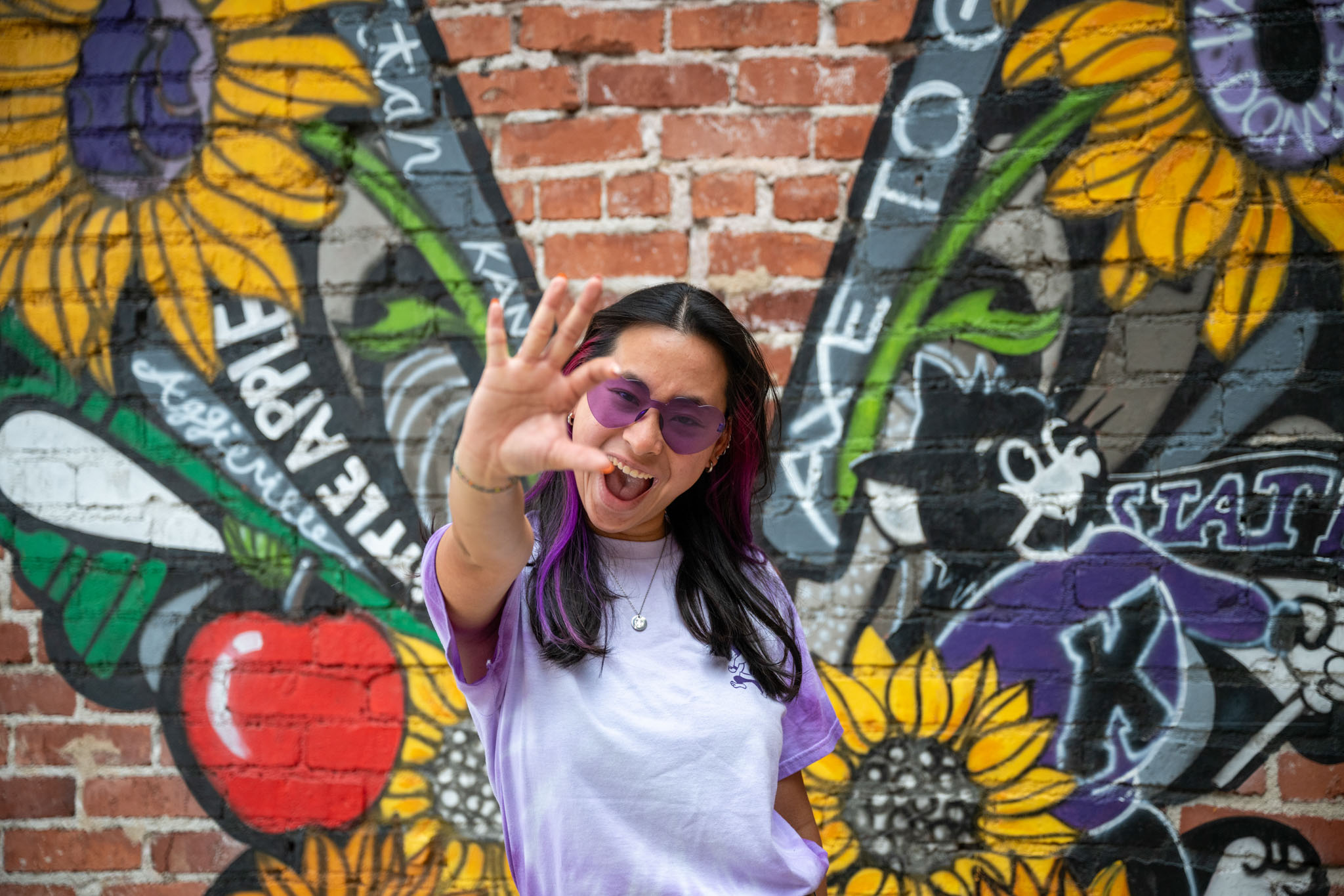 Student in front of a butterfly wall mural