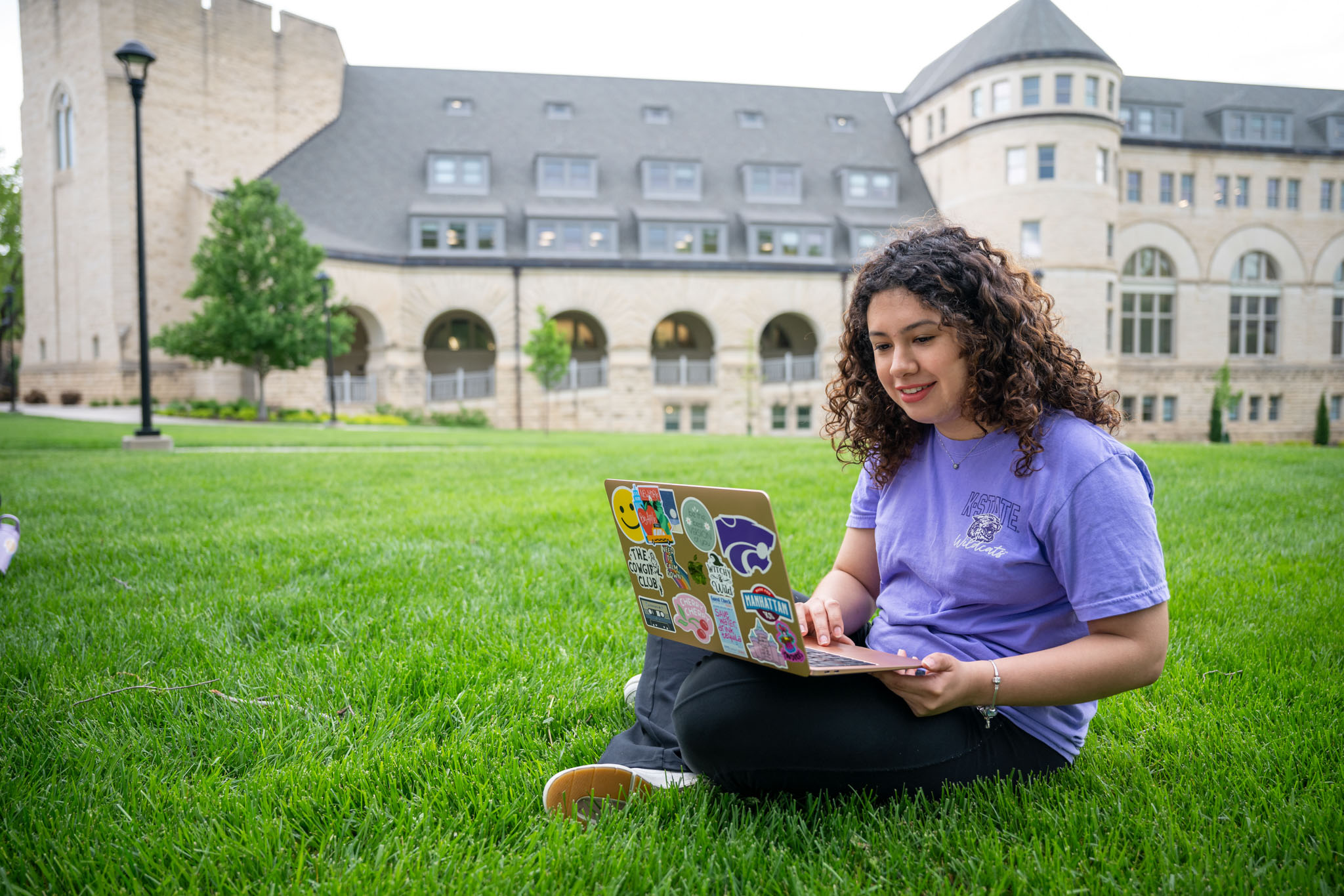 Student sitting in grass on her computer
