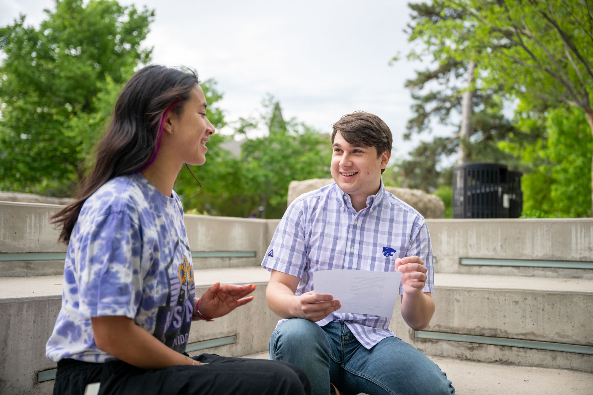Two students sitting outside on the stairs. 