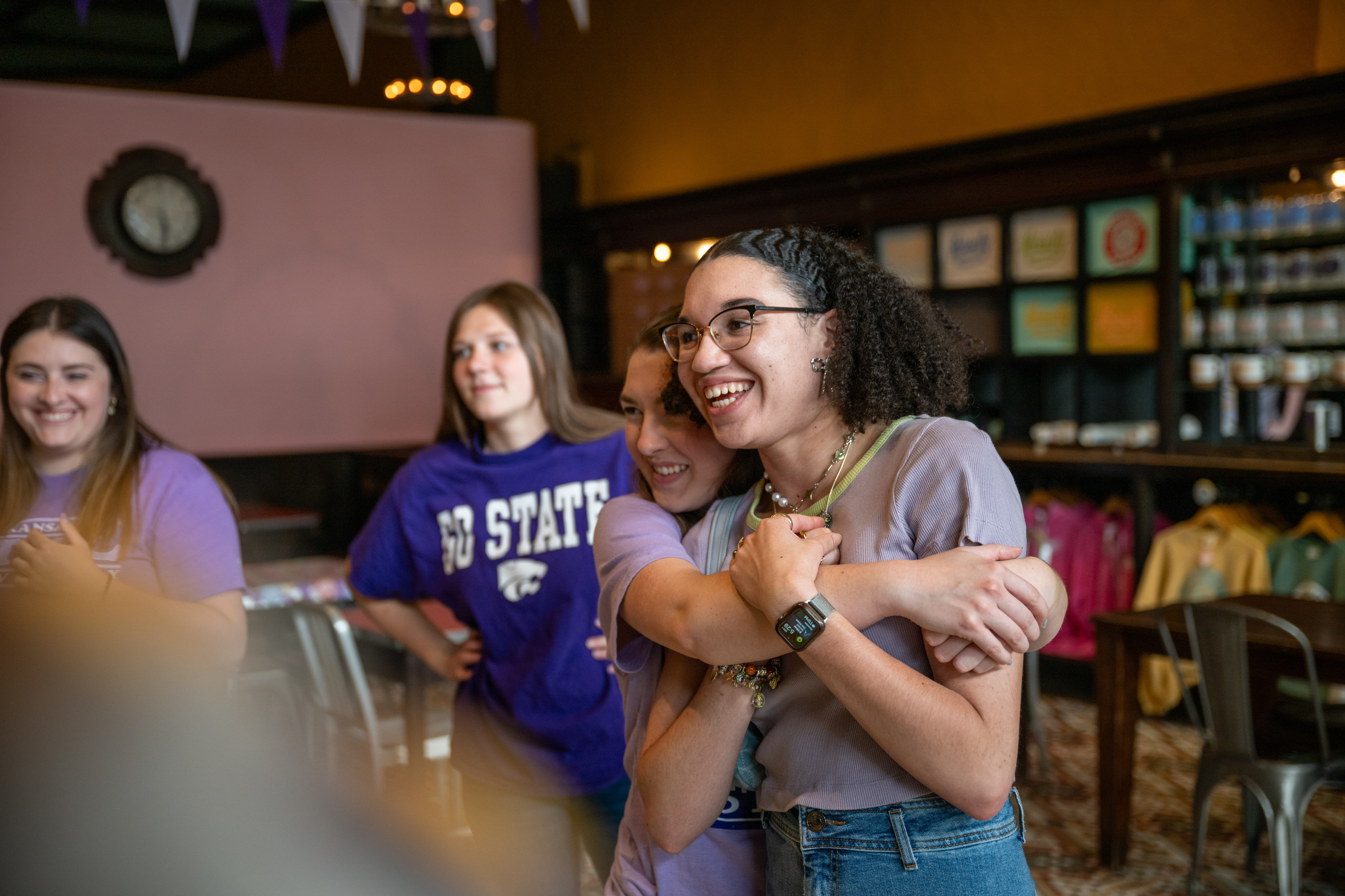Two students hugging in a store in Aggiville