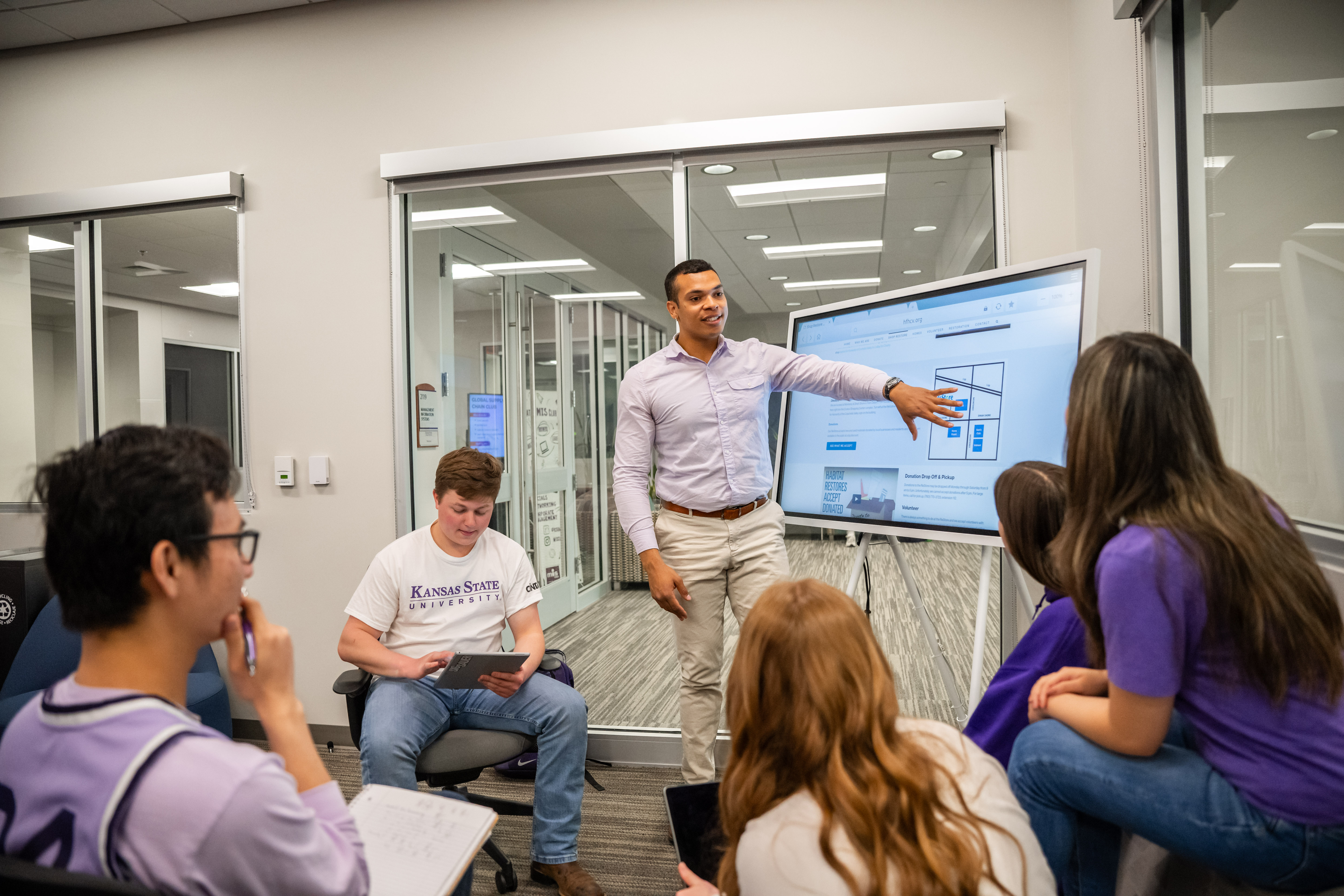 Student presenting on a smart board to other students