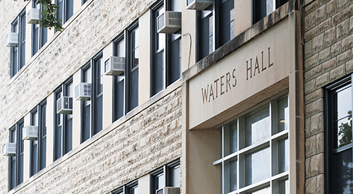 The entrance way of Waters Hall, a large sandstone building.