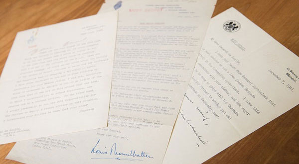 Three historical, typewritten papers arranged on a table.