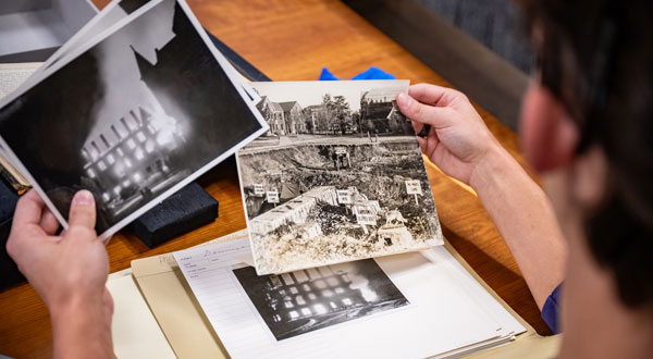 Person holds up two old photos to review.