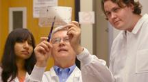 Image of Dr. Michal Zolkiewski explaining research results to lab staff