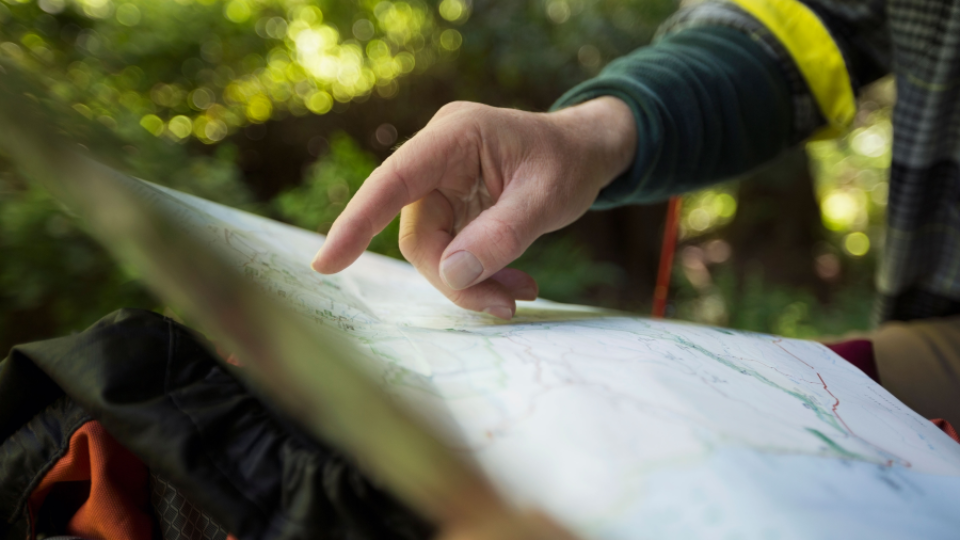 person pointing at a map, outdoors