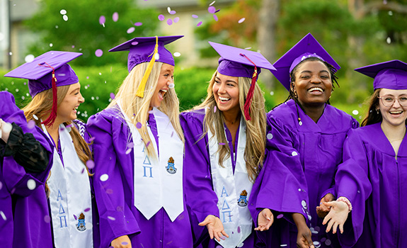Students in purple caps and gowns